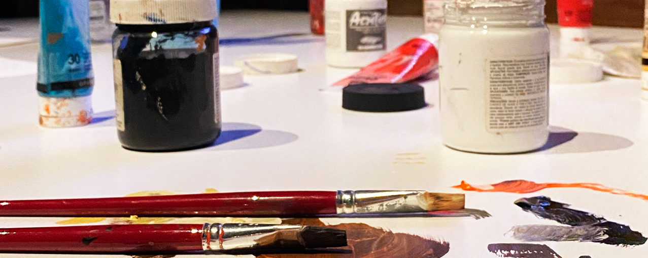 Materiais de pintura em cima de uma mesa branca.