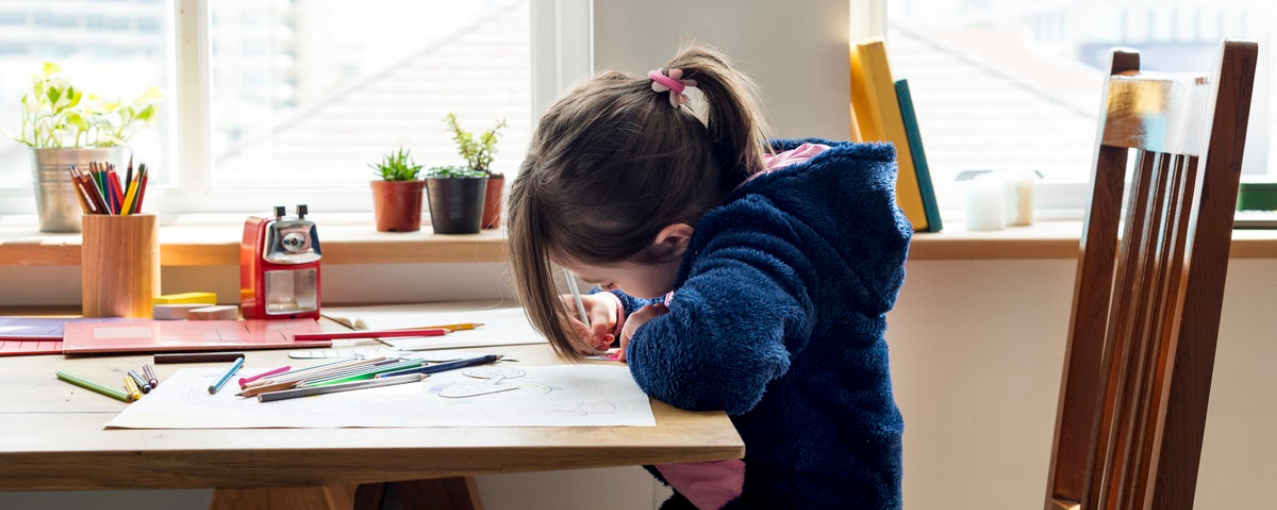 Criança em uma mesa escrevendo